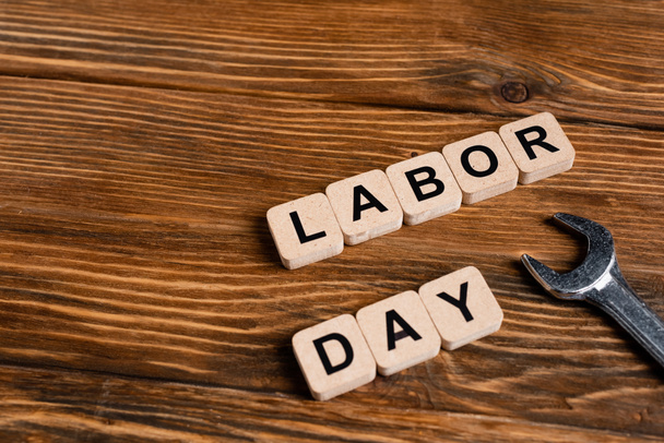 wrench near cubes with labor day lettering on wooden table - Photo, Image
