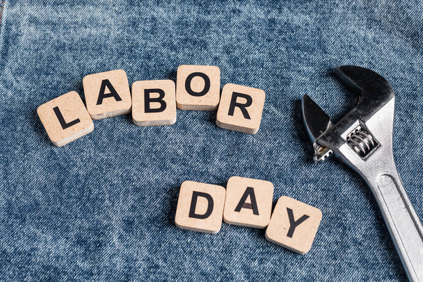 top view of cubes with labor day lettering near wrench on denim clothes - Foto, Imagem