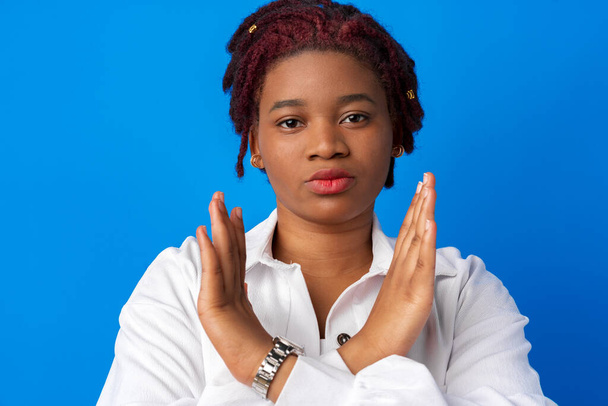 Young afro american woman standing with crossed hands on blue background - Foto, Imagem