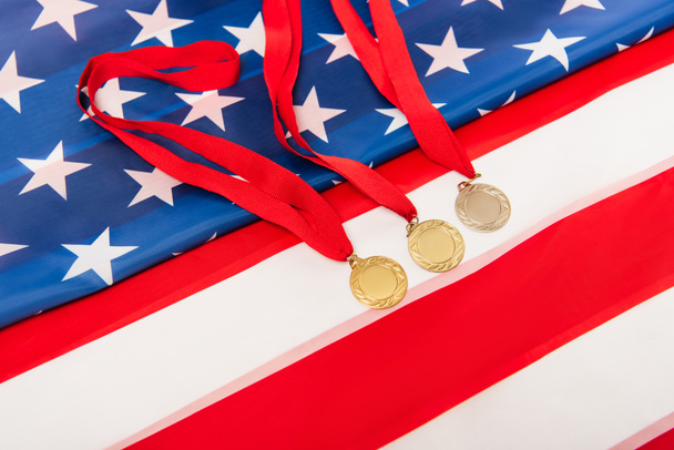 vista ad alto angolo di medaglie d'oro sulla bandiera americana - Foto, immagini