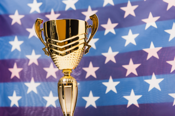 copa dorada con estrellas de bandera americana sobre fondo borroso - Foto, Imagen
