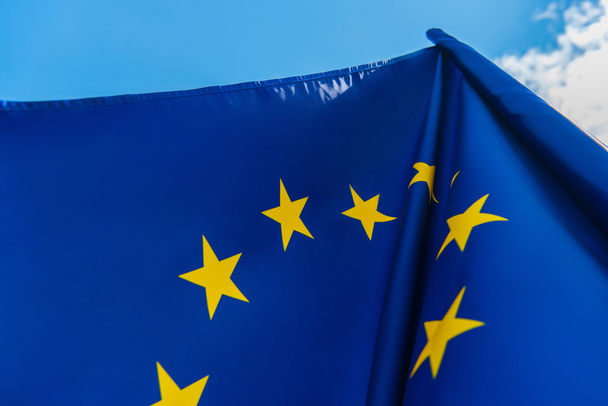 низкоугольный вид синего флага Европейского Союза на фоне неба  - Фото, изображение