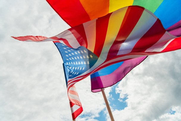 vue du bas des drapeaux lgbt américains et colorés contre le ciel  - Photo, image