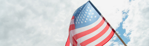 Bulutlu gökyüzüne karşı Amerikan bayrağının alçak açılı görüntüsü, afiş - Fotoğraf, Görsel