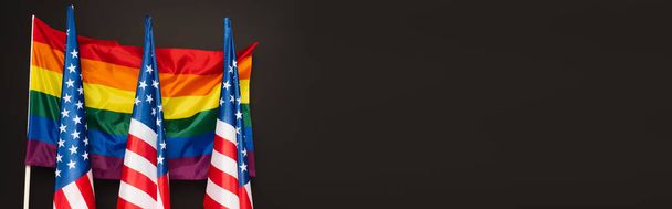 Αμερικανικές και πολύχρωμες σημαίες Igbt που απομονώνονται σε μαύρο, banner - Φωτογραφία, εικόνα