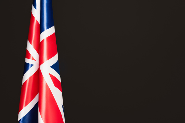 Nationalflagge des Vereinigten Königreichs mit rotem Kreuz isoliert auf schwarz mit Kopierraum  - Foto, Bild