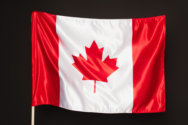 Canadian flag with red maple leaf isolated on black - Фото, зображення