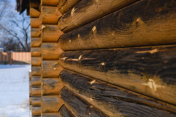 Hermoso patrón de textura de casa de campo de madera villa en el fondo de invierno durante el día soleado, troncos sin pintar - Foto, Imagen