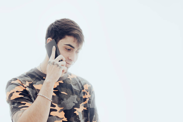 Nuori mies puhuu matkapuhelimen kanssa - Valokuva, kuva