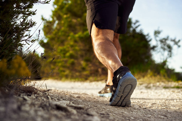 Close up of male muscular legs running up the hill - Foto, Imagem