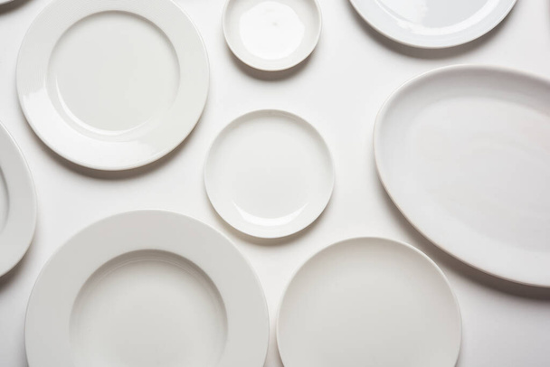 different shape white plates isolated on white background, top view - Valokuva, kuva