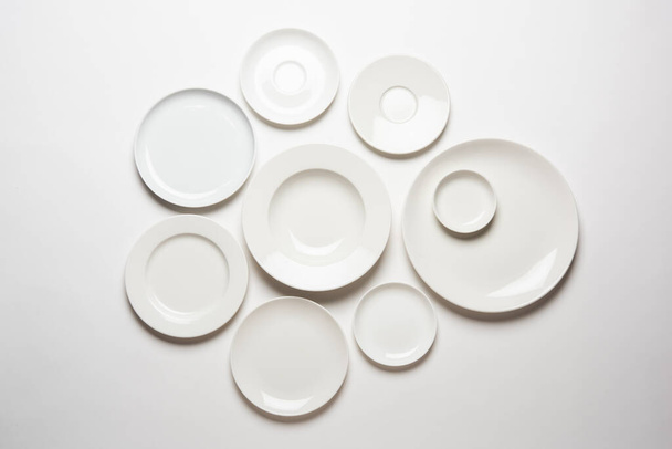 verschillende vorm witte platen geïsoleerd op witte achtergrond, bovenaanzicht - Foto, afbeelding