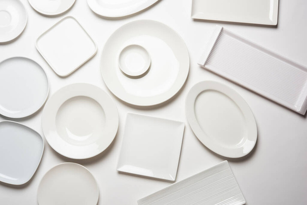 verschillende vorm witte platen geïsoleerd op witte achtergrond, bovenaanzicht - Foto, afbeelding