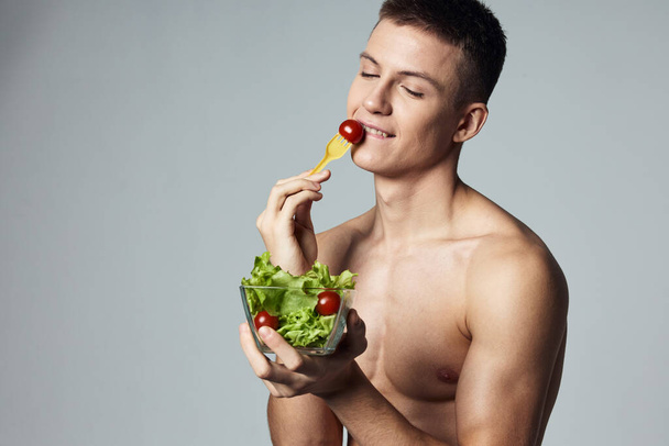 Veselý muž se svalnatým trupem zeleninový salát jíst zdravé potraviny oříznuté pohled - Fotografie, Obrázek