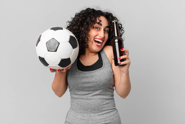 pretty arab woman with a soccer ball and having a beer - Zdjęcie, obraz