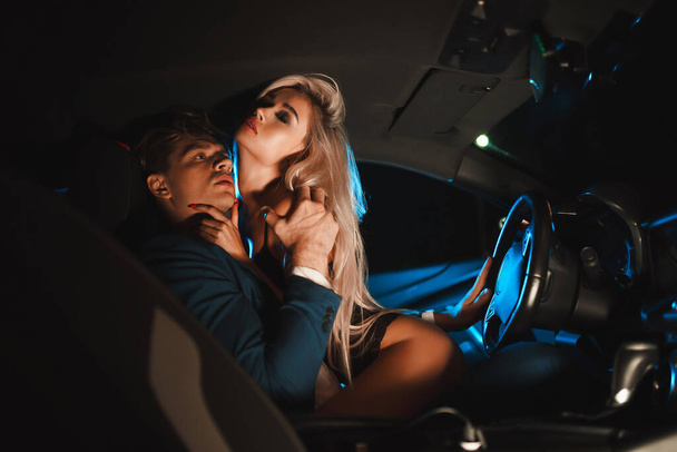 Couple kissing at night in the car. Gentle night photo session in the city. Summer vacation for lovers. - Fotoğraf, Görsel
