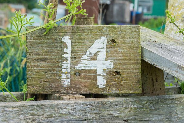 Sinal de madeira dando número de parcela de jardim
 - Foto, Imagem