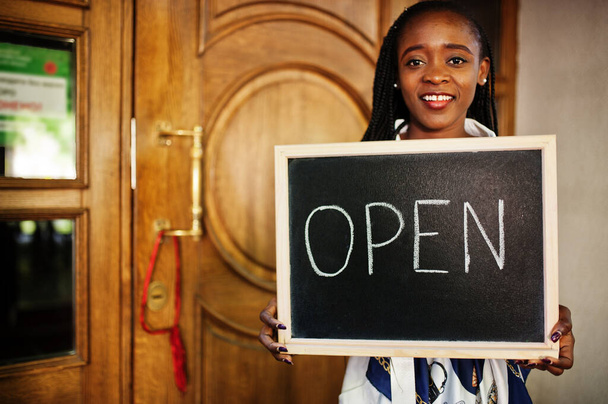 African american woman hold open welcome sign board in modern cafe coffee shop ready to service, restaurant, retail store, small business owner. - Foto, Bild
