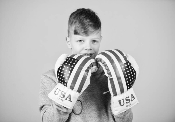 Start boxing career. American boxer concept. Child sporty athlete practicing boxing skills. Boxing sport. Towards victory. Confident in his strength. Boy sportsman wear boxing gloves with usa flag - Fotografie, Obrázek