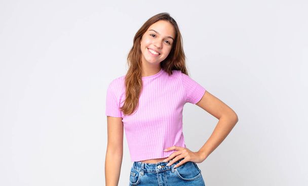 young pretty woman smiling happily with a hand on hip and confident - Фото, изображение
