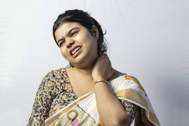 Isolé sur fond blanc une Indienne en saree tenant le cou face à la douleur - Photo, image