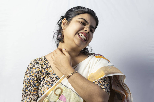 isoliert auf weißem Hintergrund eine indische Frau im Sari, die wegen Hautausschlägen am Hals juckt - Foto, Bild