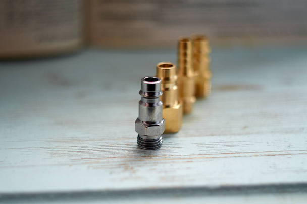 Set of stainlees steel and brass male couplings on the wood - Photo, Image