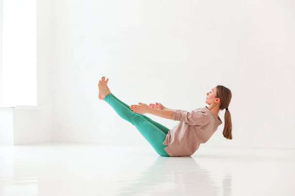 Nyugodt női sportruházat gyakorló jóga Firefly pózban, miközben kiegyensúlyozza és félrenéz - Fotó, kép