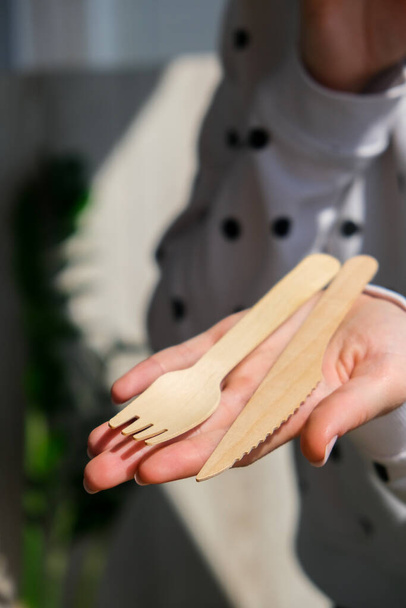 Female hands holding Wooden forks and paper cups with plates. Eco friendly disposable tableware. Used in fast food, restaurants, takeaways, picnics. No plastic Zero waste - Fotoğraf, Görsel
