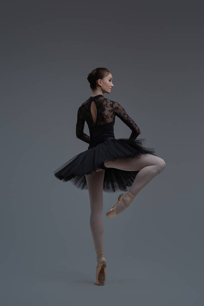 Rear view of ballerina wearing dress dancing inside studio - Foto, immagini