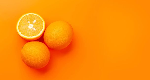 Fruta naranja madura fresca sobre fondo naranja. Vista superior plano con espacio de copia - Foto, Imagen