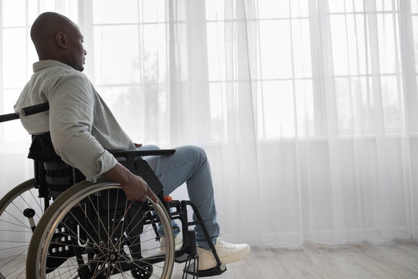 Gehandicapte man zit in rolstoel in ziekenhuis of huis, volwassen gehandicapt in invalide vervoer of rolstoel - Foto, afbeelding