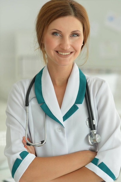 Portrait of smiling female doctor showing clipboard in hospital  - Фото, изображение