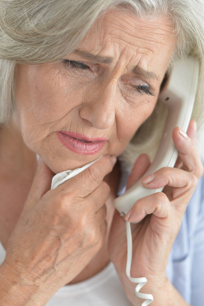 sad senior woman talking on phone - Фото, изображение