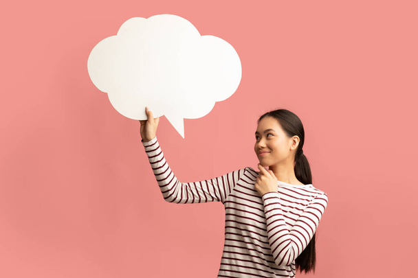 Idea. Pensativo mujer asiática mirando en blanco discurso burbuja y tocando barbilla - Foto, imagen
