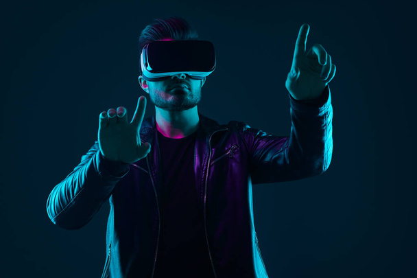 Άνθρωπος σε VR ακουστικά που αλληλεπιδρούν με τον εικονικό κόσμο - Φωτογραφία, εικόνα