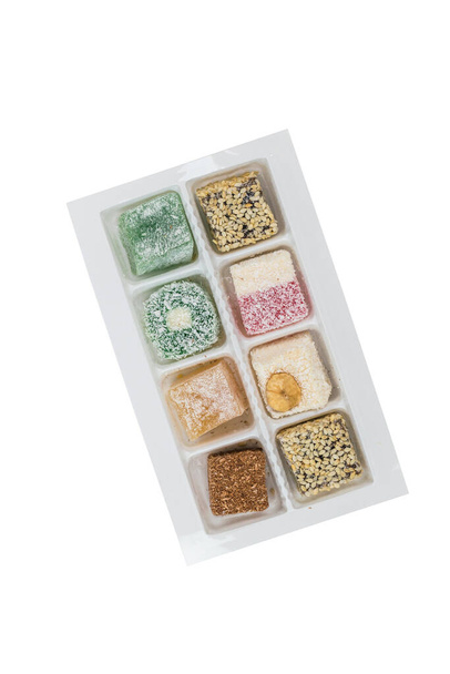 Assorted Turkish delight in a plastic box isolated on a white background. Oriental sweets. - Photo, Image