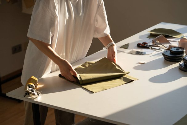 Primer plano de la tela de retención de alcantarillado femenino para cortar trabajando en taller estudio. Proceso creativo en el taller - Foto, Imagen
