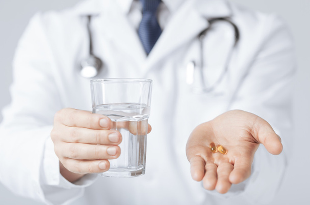 doctor hands giving capsule and glass of water - Photo, image
