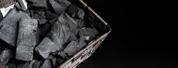 Černé uhlí na černé texturované podlaze. dřevěné uhlí černý uhlíkový kal produkovaný silně zahřívajícím dřevem. Používá se pro vaření nebo jiná odvětví. Dřevěné uhlí. tradiční dřevěné uhlí. - Fotografie, Obrázek
