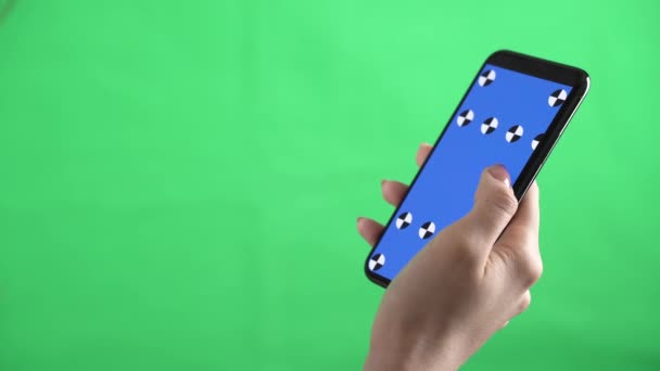 Ένα άτομο κρατά ένα smartphone με δείκτες εντοπισμού σε αυτό και το σκούπισμα αριστερά στο πλήκτρο chroma - Πλάνα, βίντεο