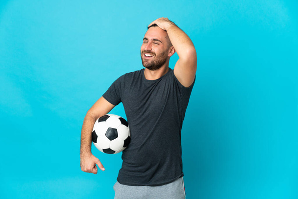 Ποδοσφαιριστής απομονωμένος σε μπλε φόντο έχει συνειδητοποιήσει κάτι και την πρόθεση της λύσης - Φωτογραφία, εικόνα