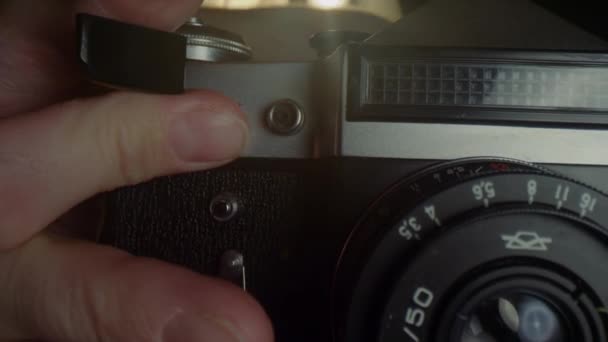 Ruce mužského fotografa znovu nahrají film ve staré mechanické kameře. - Záběry, video