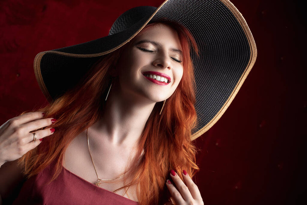 redhead woman, girl in a dark key, sexy and painted red lips - Photo, Image