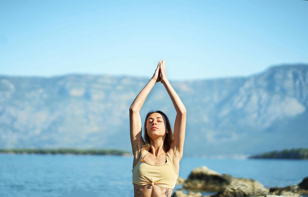 Woman doing morning yoga session process meditation practice with mountains landscape - Fotó, kép