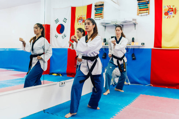 Two young women practice taekwondo in a training center - Photo, Image