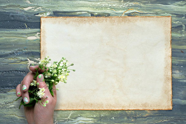 Text Alles Gute zum Geburtstag means Happy Birhday in German. Greeting on aged patchment, beige paper page. Hand hold pale yellow flowers. Flat lay on aged textured painted green brown background. - Fotó, kép