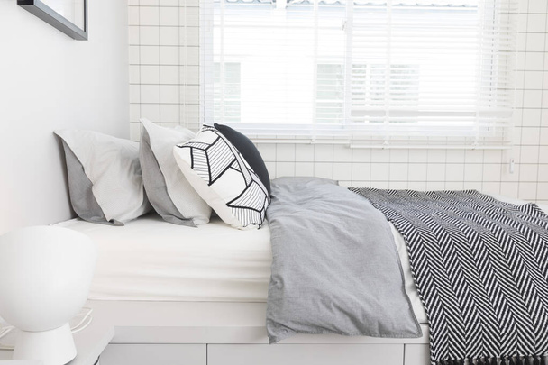 Dormitorio para un hombre solitario y elegante. Habitación moderna con interiores grises de moda con patrón gráfico. - Foto, imagen