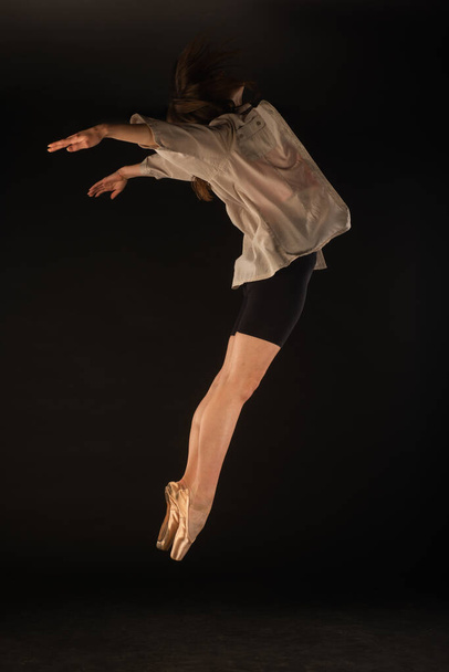 Ballerina is having a perfect ballet jump while posing - Foto, Imagen