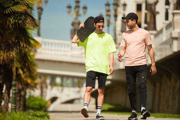 Két fitt férfi barát együtt sétál, miközben beszélgetnek valamiről. - Fotó, kép